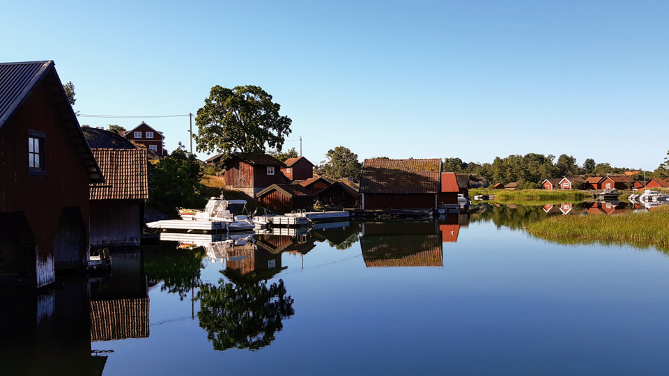 Hamn med sjöbodar och båtar i skärgården