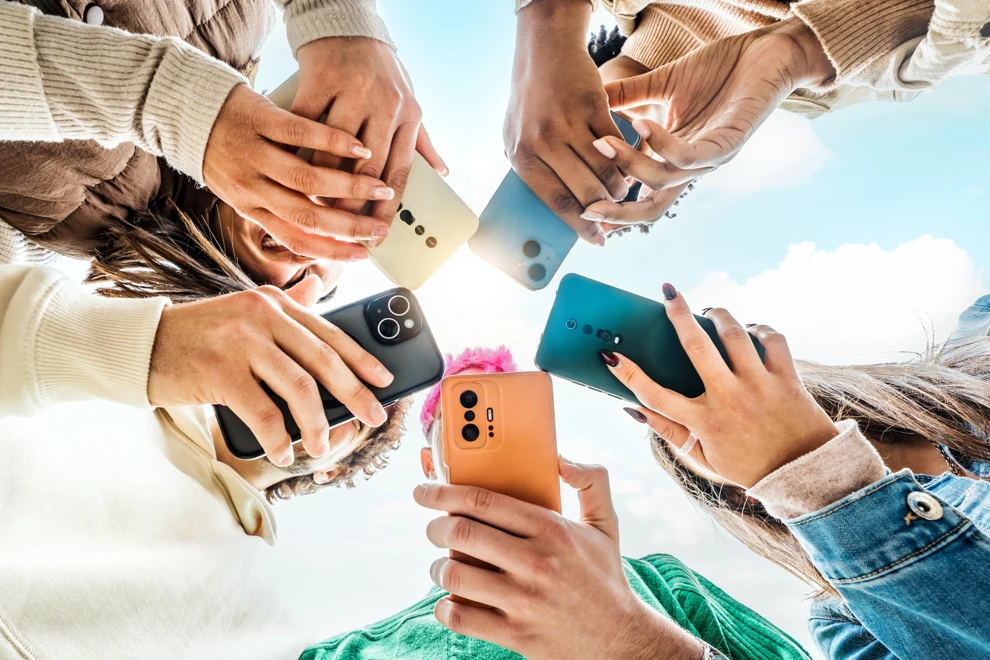 En grupp människor som står i en ring och håller i sina mobiltelefoner.