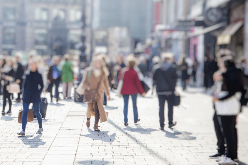 Människor på ett torg med byggnader i bakgrunden