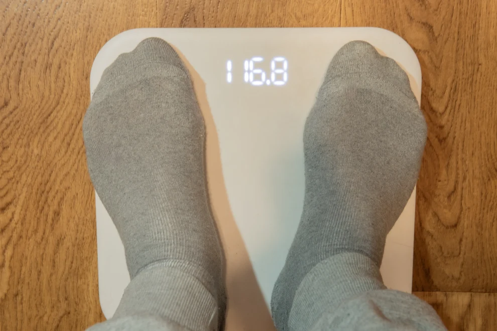 Två fötter på en våg. Vågen visar 116 kilo.