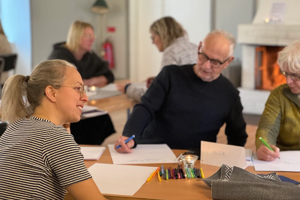 En grupp människor som sitter runt ett träbord.