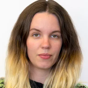 En kvinna med blont hår och en svart tröja.